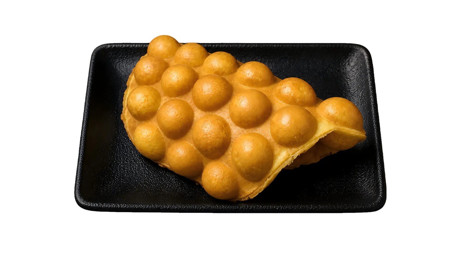 Golden Hong Kong-style egg waffle served on a black plate Golden Hong Kong-style egg waffle served on a black plate