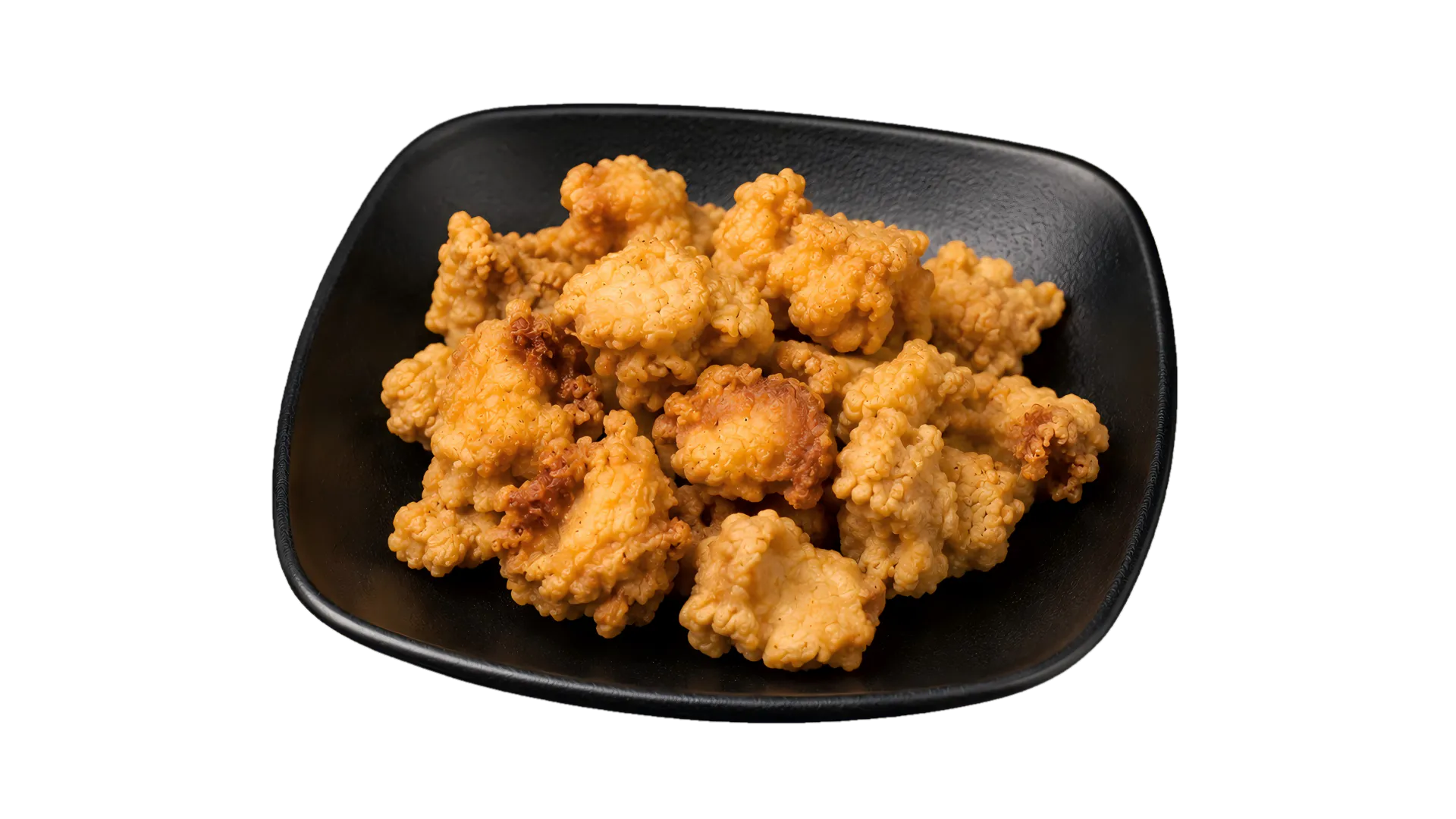 Golden crispy popcorn chicken served on a black plate Golden crispy popcorn chicken served on a black plate